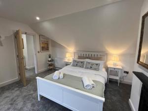 um quarto com uma cama branca e 2 almofadas em The Loft at Scalford House em Melton Mowbray