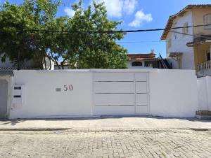 eine weiße Garagentür mit der Nummer drauf in der Unterkunft Aconchego do Bem-te-vi 2 qtos 60m2 Praia Grande in Arraial do Cabo