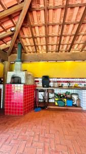 Zimmer mit Backsteinboden und gelben Wänden in der Unterkunft Chácara Cajueiro in Araras
