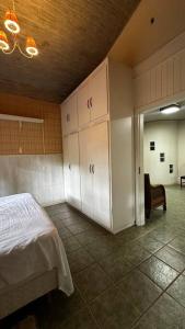 ein Schlafzimmer mit einem Bett und ein Zimmer mit einem Stuhl in der Unterkunft Chácara Cajueiro in Araras