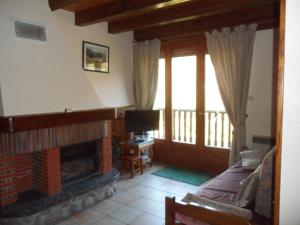 sala de estar con chimenea y TV en Appt 4 pers-chalet l'ancienne école en La Bresse