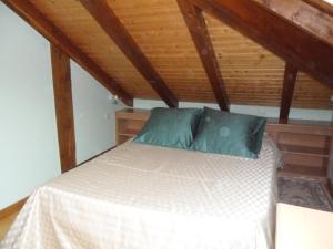 Cama en habitación con techo de madera en Appt 4 pers-chalet l'ancienne école en La Bresse