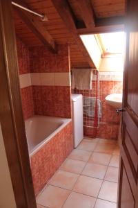 Baño pequeño con bañera y lavamanos en Appt 4 pers-chalet l'ancienne école en La Bresse