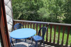 a blue table and chairs on a porch with a view at Appt 4 pers-chalet l'ancienne école in La Bresse