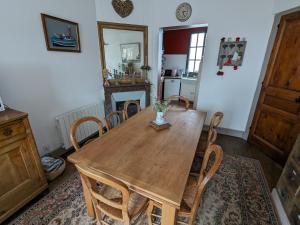 勒泰波爾的住宿－Maison Côté Mer，一间带木桌和椅子的用餐室