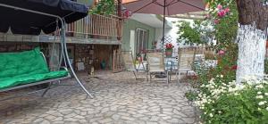 eine Terrasse mit Stühlen, einem Sonnenschirm und einem Tisch in der Unterkunft Blue Fairytale in Agios Nikolaos