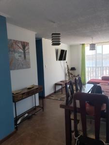 sala de estar con mesa y comedor en Dichato Borde Bahía Azul, en Tomé