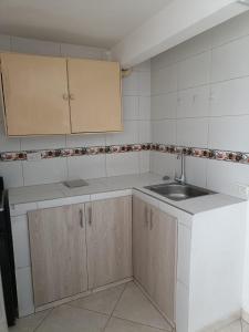 a kitchen with white cabinets and a sink at San antonio urbano in Bogotá