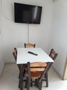 a white table with two chairs and a television on a wall at San antonio urbano in Bogotá