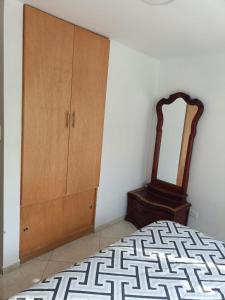 a bedroom with a bed and a dresser and a mirror at San antonio urbano in Bogotá