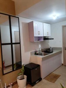 a kitchen with white cabinets and a sink at La studio tropical manila in Manila