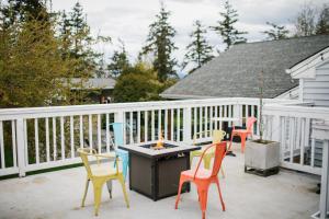 eine Terrasse mit Stühlen, einem Tisch und einer Feuerstelle in der Unterkunft Friday Harbor Suites in Friday Harbor