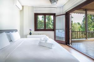 a bedroom with a bed with a tub and a window at Iconic PRIVE beachfront villa Mola Kaliva in Mola Kalyva