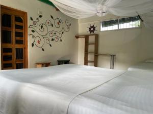 a bedroom with a white bed and a window at Hostal Luz de Luna in Palomino