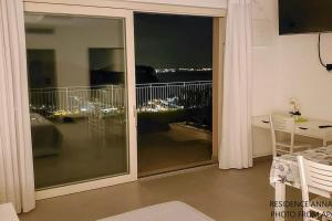 um quarto com uma grande porta de vidro deslizante e uma varanda em Appartamenti Annachiara em Costermano