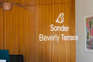 een bord op een houten deur in een kamer bij Beverly Terrace powered by Sonder in Los Angeles