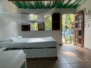 1 Schlafzimmer mit 2 Betten in einem Zimmer mit Fenstern in der Unterkunft Hostal Luz de Luna in Palomino