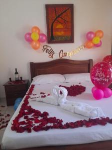 uma cama com um monte de rosas e balões em Hotel Asturias Campestre em San Gil