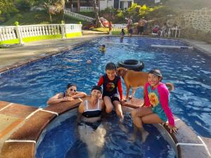 um grupo de pessoas sentadas numa piscina em Hotel Asturias Campestre em San Gil