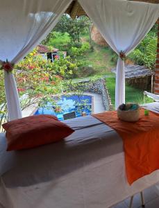 um quarto com uma cama e vista para uma piscina em Hotel Asturias Campestre em San Gil