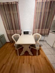 une table blanche avec des chaises et un four micro-ondes. dans l'établissement willana, à Schönebeck