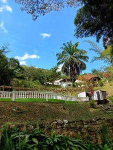 uma cerca branca num quintal com uma palmeira em Hotel Asturias Campestre em San Gil