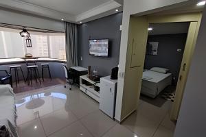 a living room with a bed and a dining room at Apartamento Docelar Garagem Feirinha e Hospitais in São Paulo