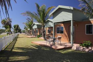 une maison avec une table et des chaises sur une terrasse couverte dans l'établissement Ningaloo Coral Bay – Bayview, à Coral Bay