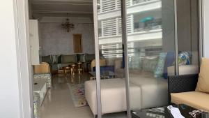 uma sala de estar com um sofá, uma mesa e cadeiras em Très bel appartement neuf à Mansbay Manssouria em Mohammedia