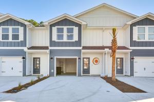 una casa con una palmera delante en Santa Rosa Beach Townhome about 4 Mi to Beach!, en Santa Rosa Beach
