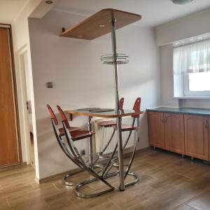 a kitchen with a table and some chairs around it at Apartament Poranek in Grzybowo +3 photos