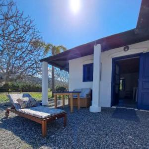 a couch and a table in front of a house at Lovely independent room in Ecovilla on the beach in Apolakkiá