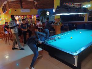 a woman standing in front of a pool table at Hotel Palm Rock Beach in San-Pédro