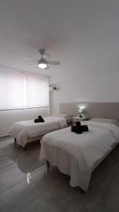 Pokój z 2 łóżkami i wentylatorem sufitowym w obiekcie FUENGIROLA CENTRO w mieście Fuengirola