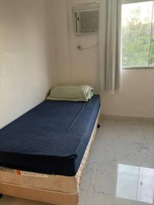 1 cama en una habitación con ventana en Apartamento, en Río de Janeiro