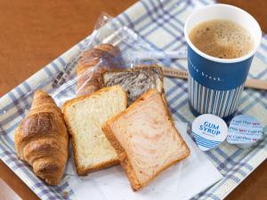 uma bandeja de pão e croissants e uma chávena de café em APA Hotel Niigata Higashinakadori em Niigata
