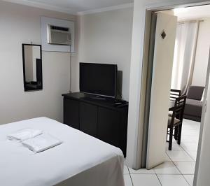 a hotel room with a bed and a television at Apart Acolhedor 5 pessoas Hakka Eventos, Hospitais e Feirinha in Sao Paulo