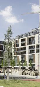 a large building with tables and chairs in front of it at CityLife Apartments Stuttgart Europa Viertel in Stuttgart