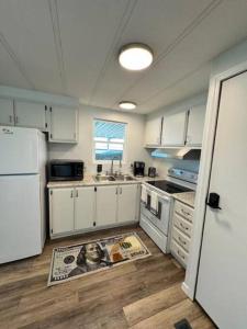 a kitchen with white cabinets and a sink and a refrigerator at Herbster Hideaway in Parker