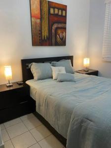 a bedroom with a large bed with two lamps at Fiesta Spot at La Placita in San Juan
