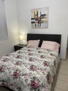 a bedroom with a bed with a floral comforter at Fiesta Spot at La Placita in San Juan