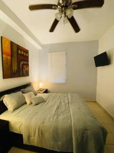 um quarto com uma cama e uma ventoinha de tecto em Fiesta Spot at La Placita 3 BR and 2 Bathrooms em San Juan