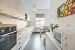 Una cocina con gabinetes blancos y una mesa en ella. en Como 101, centro città, en Como