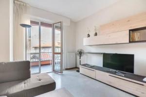 Una sala de estar con un televisor grande y un sofá. en Como 101, centro città, en Como