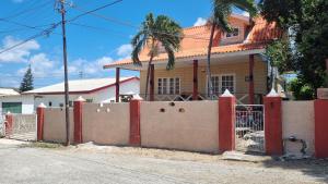 a house with a fence in front of it at Villa Tutilia in Willemstad