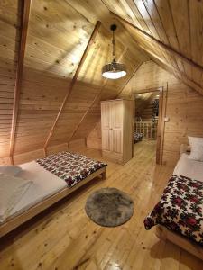 a room with two beds in a wooden cabin at Chaty pod Pilskiem - sauna i jacuzzi - Krzyżówki - Korbielów in Krzyżowa