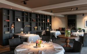 a dining room with tables with white tablecloths at Restaurant-Hotel de Watergeus in Noorden