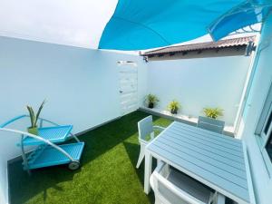 a small balcony with a blue table and chairs at Paradise Studio Aruba in Palm-Eagle Beach