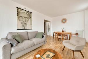 sala de estar con sofá y mesa en Le Boho Zen - spacieux F3 avec parking proche Paris, en Épinay-sur-Seine