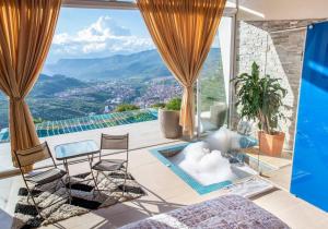 een woonkamer met uitzicht op de bergen bij Glamping Luxury vista infinita y Jaccuzi en Sangil in San Gil